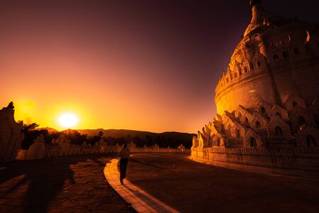 The Hsinbyume Pagoda in Mingun Myanmar Tourist Woman walks towards the Beautiful golden Sunsetの写真素材