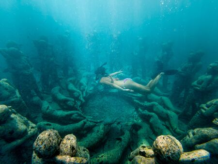 Young girl freediving too see underwater sculptures in Gili Meno Indonesiaの写真素材