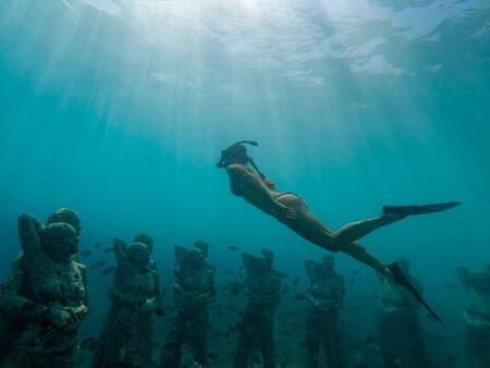 Young girl freediving too see underwater sculptures in Gili Meno Indonesiaの写真素材