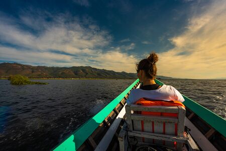 Tourist admire beautiful scenery from the boat on Inle Lake. Shan state, Myanmar