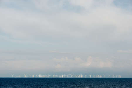 Windmill farm on the sea from the distance with copy spaceの写真素材