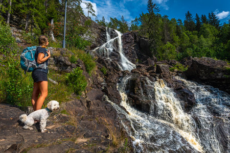 Tourist admires Elgafossen - Algafallet Waterfall shared between Sweden and Norwayの写真素材