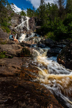 Tourist admires Elgafossen - Algafallet Waterfall shared between Sweden and Norwayの写真素材