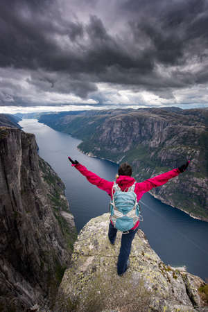 Backpacker in Victory pose, Eagle Head Viewpoint near Kjeragboltenの写真素材