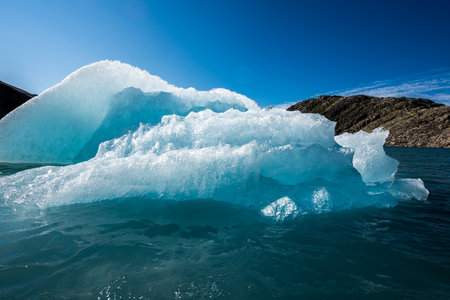Chunk of Glacier ice lit by rising sun Folgefonna Glacier Mosevatnet Lake, Norwayの写真素材