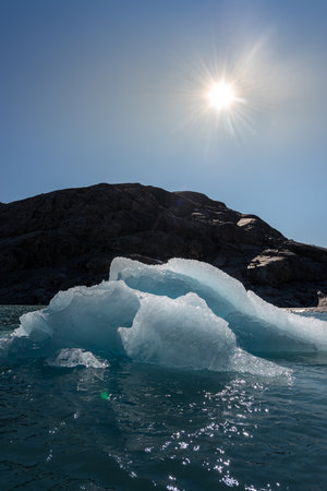 Chunk of Glacier ice lit by rising sun Folgefonna Glacier Mosevatnet Lake, Norwayの写真素材