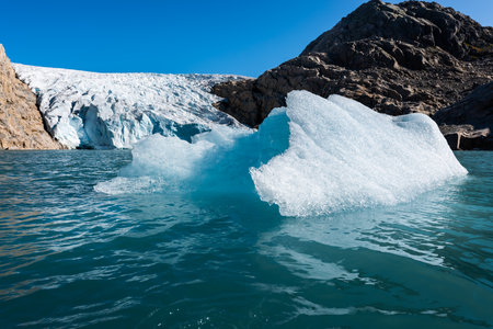 Chunk of Glacier ice lit by rising sun Folgefonna Glacier Mosevatnet Lake, Norwayの写真素材