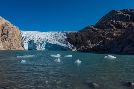 Chunks of Glacier ice lit by rising sun Folgefonna Glacier Mosevatnet Lake, Norwayの写真素材