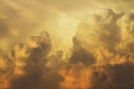 Colorful orange and yellow puffy storm clouds at sunset 