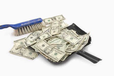 Broom sweeping up American Money の写真素材