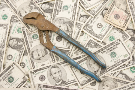 Pliers on background of American money  の写真素材