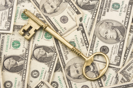 Brass key on background of American currency の写真素材