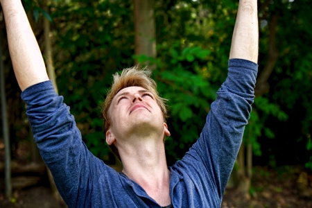man wearing a long sleeve blue t-shirt with his arms held highの写真素材