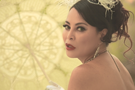 Closeup portrait of Asian woman framed by a parasol with light shining through
