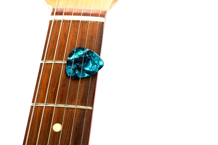 A guitar pick is placed between the strings of a electric guitar の写真素材