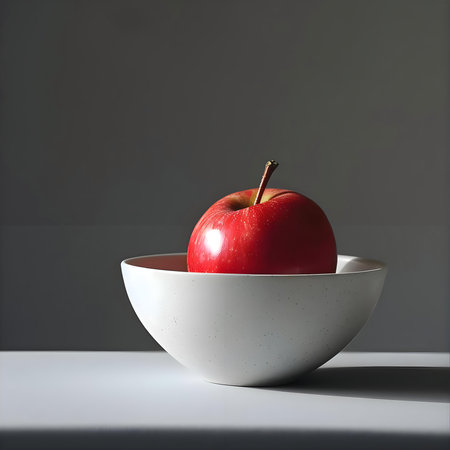 a red apple sitting in a white bowlの素材
