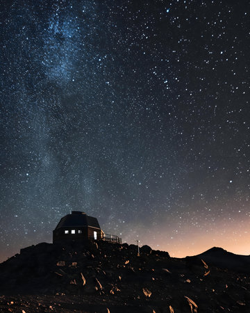 a house on a hill under a night sky filled with starsの素材