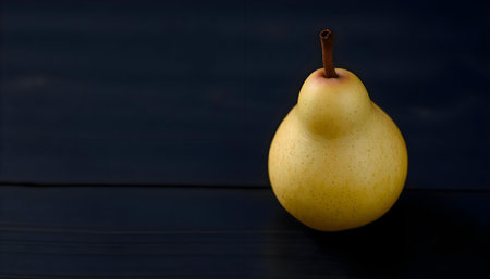 a yellow pear sitting on top of a black tableの素材