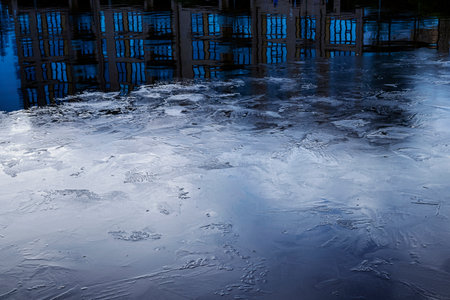 Surface of frozen lake with reflection of lakeside apartments at Caldecotte lakeの写真素材