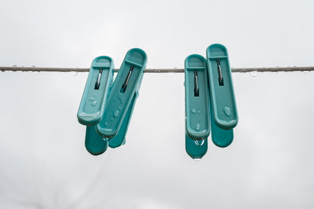 clothespins on a clothesline with a cloudy sky in the backgroundの写真素材