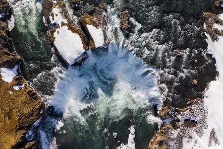 Aerial view of Godafoss waterfall, snowy shore and river. Iceland in early spring.の写真素材