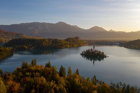 Aerial view of the colorful forest and Lake Bled with a small island with a church. Sunrise in Slovenia in the fall.の写真素材