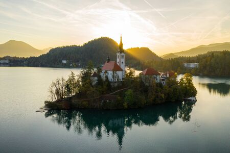 Aerial view of the colorful forest and Lake Bled with a small island with a church. Sunrise in Slovenia in the fall.の写真素材