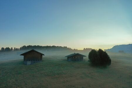 Aerial view of the valley in the fog during dawn in the Alpe di Suisi region. Dolomites in Italy in the fallの写真素材