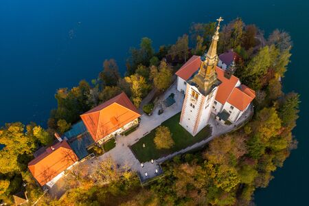 Aerial view of the colorful forest and Lake Bled with a small island with a church. Sunrise in Slovenia in the fall.の写真素材