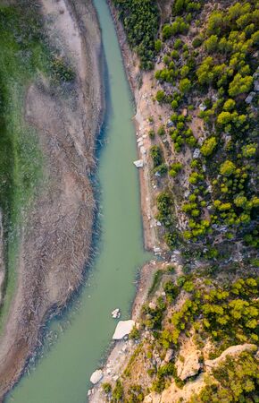 Aerial view of the valley, olive fields and Embalse de Forata reservoir during sunset. Summer in...