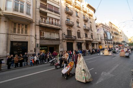 Fallera Commission parading down Calle de la Paz, seen from front, during the Fallas offering. Valencia, Spain - March 18, 2019のeditorial素材