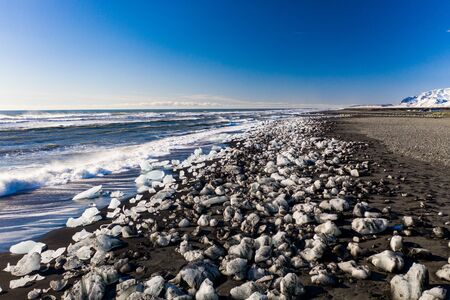 Aerial view of ice floes and icebergs on Diamond beach. The beginning of spring in Iceland