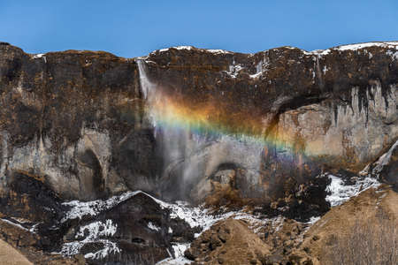 Photo of an icelandic waterfall in Iceland with a rainbow
