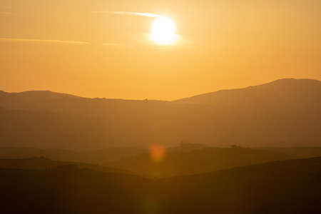 Amazing colorful sunset in Tuscany. Picturesque agritourism and typical rural landscape in Tuscany, Italy, Europe.の写真素材