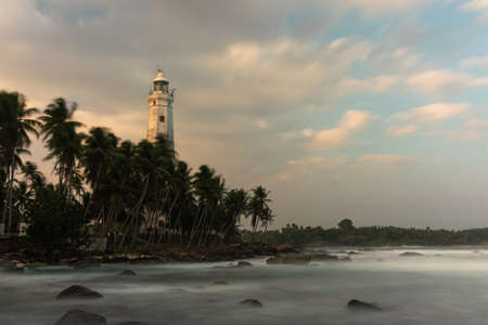 White lighthouse Dondra and tropical palm trees against the background of a fantastic sunset, Sri Lanka.の写真素材