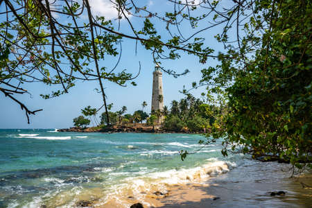 Beautiful beach and White lighthouse Dondra in Sri Lanka. View from the beach.の写真素材