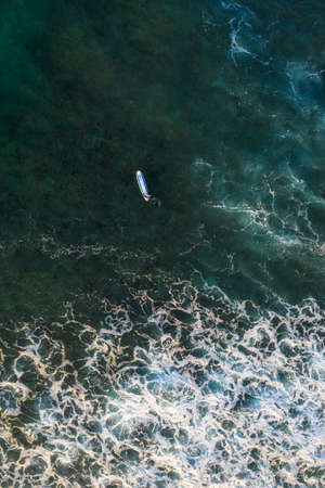 Aerial view of the beach and surfers on the island of Sri Lanka during sunriseの写真素材
