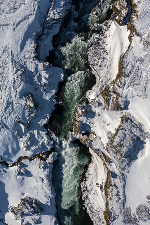 Aerial view of Godafoss waterfall, snowy shore and river. Iceland in early springの写真素材