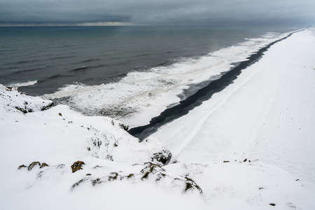 View of Kirkjufjara black sand beach from Dyrholaey promontory. Vik i Myrdal village, South Icelandの写真素材