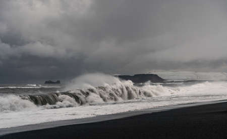Stormy waves at black volcanic beach near famous Reynisfjara rocks at south coast of Icelandの写真素材