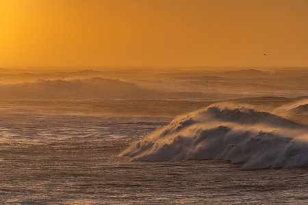 View from cape Dyrholaey on Reynisfjara Beach and Reynisdrangar basalt sea stacks, Iceland. Stormy sunriseの写真素材