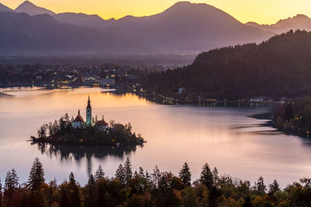 The iconic Lake Bled with St. Marys Church and the mountains against the cool autumn morning sky, Slovenia, Europe.の写真素材