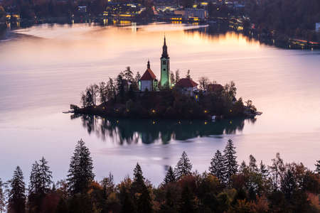 The iconic Lake Bled with St. Marys Church and the mountains against the cool autumn morning sky, Slovenia, Europe.の写真素材