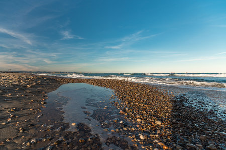 Scenic View of Albufera Lake Shores in Spain with Pebbles and Wavesの写真素材