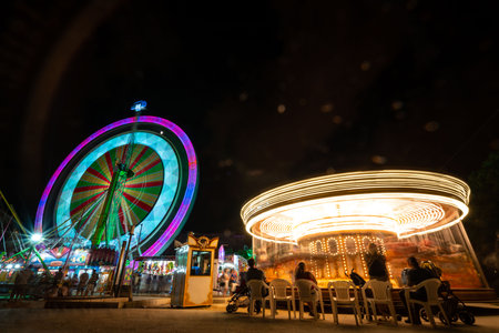 Vibrant Night Scene at Turia Park: Ferris Wheel and Carousel in Valencia