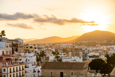 Stunning Sunset Over Ibiza Cityscape with Mountains in the Backgroundの写真素材