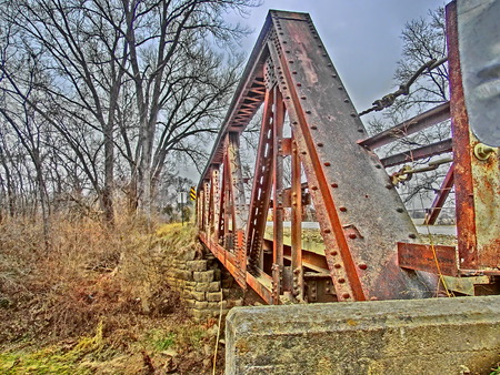 Old rusting bridge crossing a small stream.の写真素材