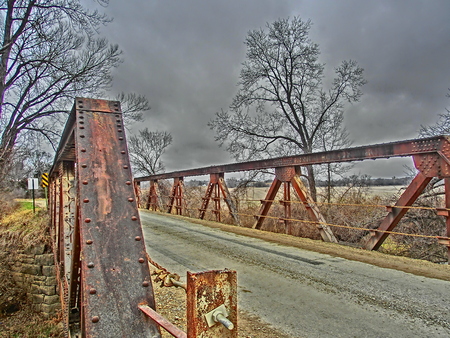 Old rusting bridge crossing a small stream.の写真素材