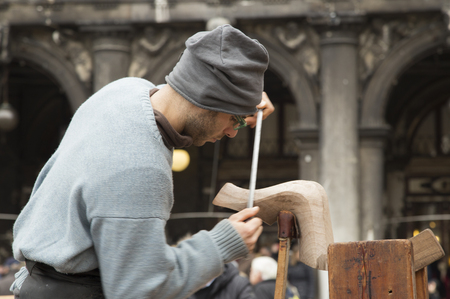 Venice, Italy - February 8, 2016 Gondola Artisan carver displays his skills at the Venice Carnival in San Marco Square to highlight the importance this untouchable cultural heritage handed down since the middle ages.のeditorial素材