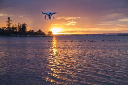 Drone flying at sunset over a lakeの写真素材